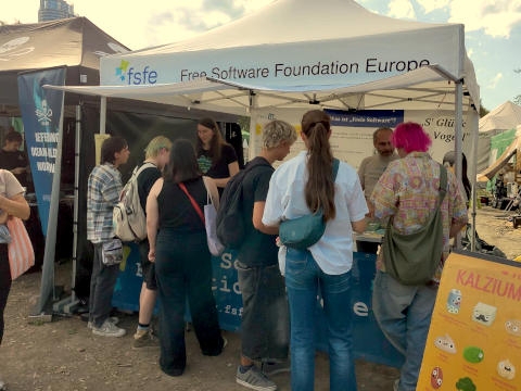 A crown of people in front of the FSFE information desk at Veganmania danube island 2026
